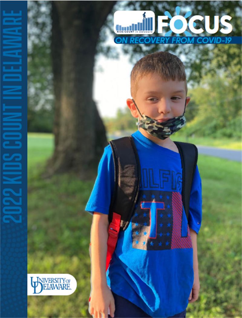 2022 KIDS COUNT in Delaware FOCUS on Recovery from COVID-19 book cover page, image of young boy with face mask lowered