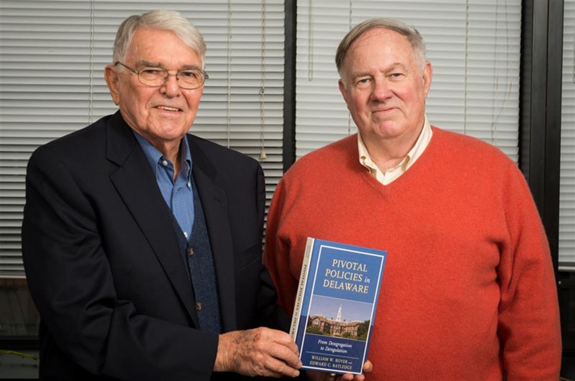 Bill Boyer and Ed Ratledge hold their book Pivotal Policies in Delaware.