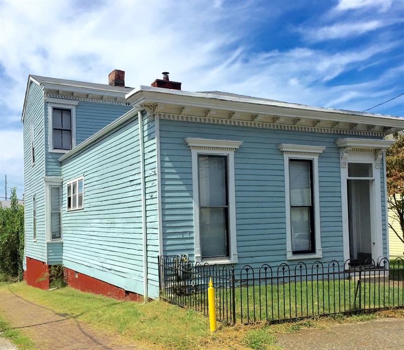 A historic home in Louisville, Kentucky, that is painted light blue.