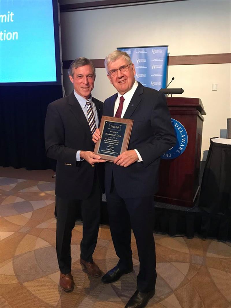 Delaware Governor John Carney presents Dr. Jerome Lewis, director of UDs Institute for Public Administration, with a plaque honoring his lifetime commitment to advancing the causes of civics education and public service.