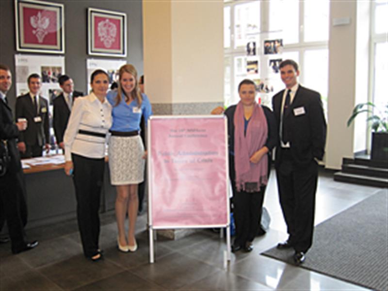 Four student researchers pose for a photo at the Warsaw conference