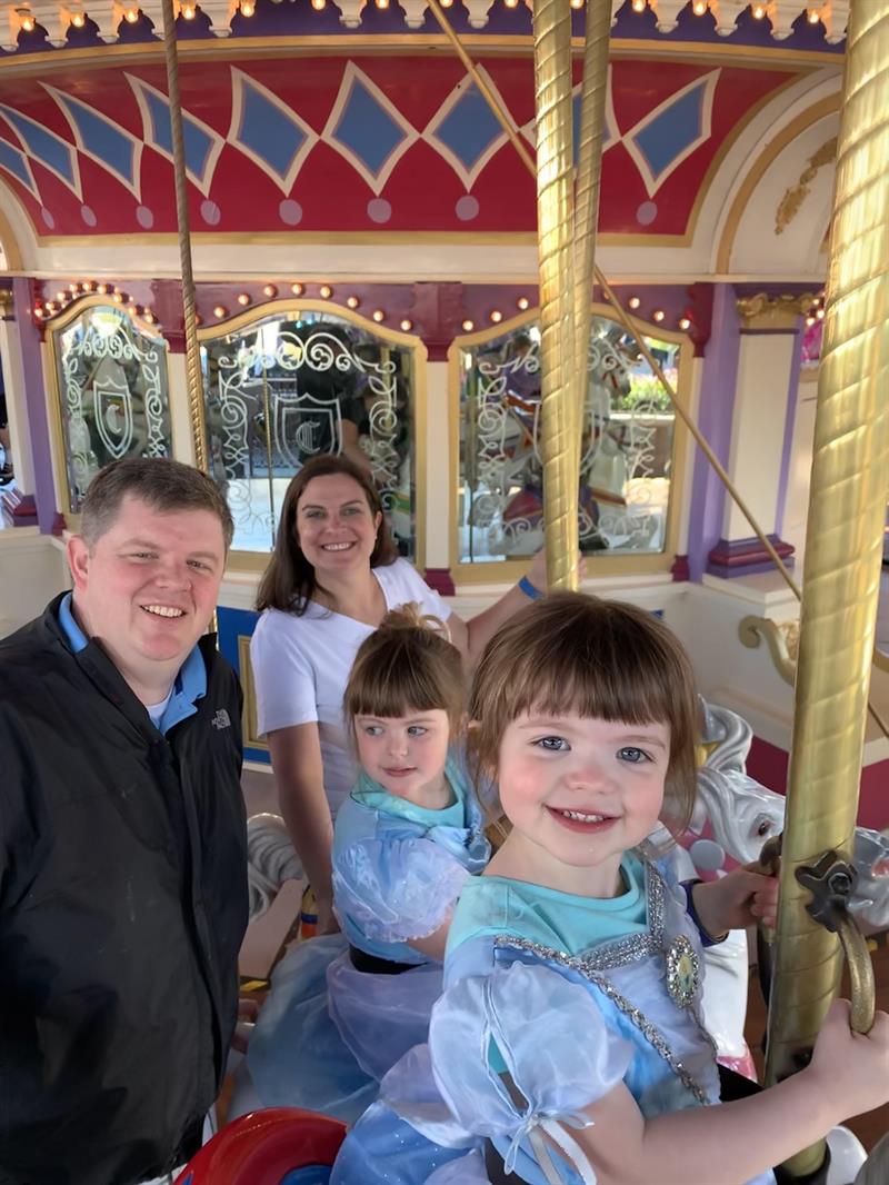 Sean O'Neill with his wife and daughters on a carousel. 