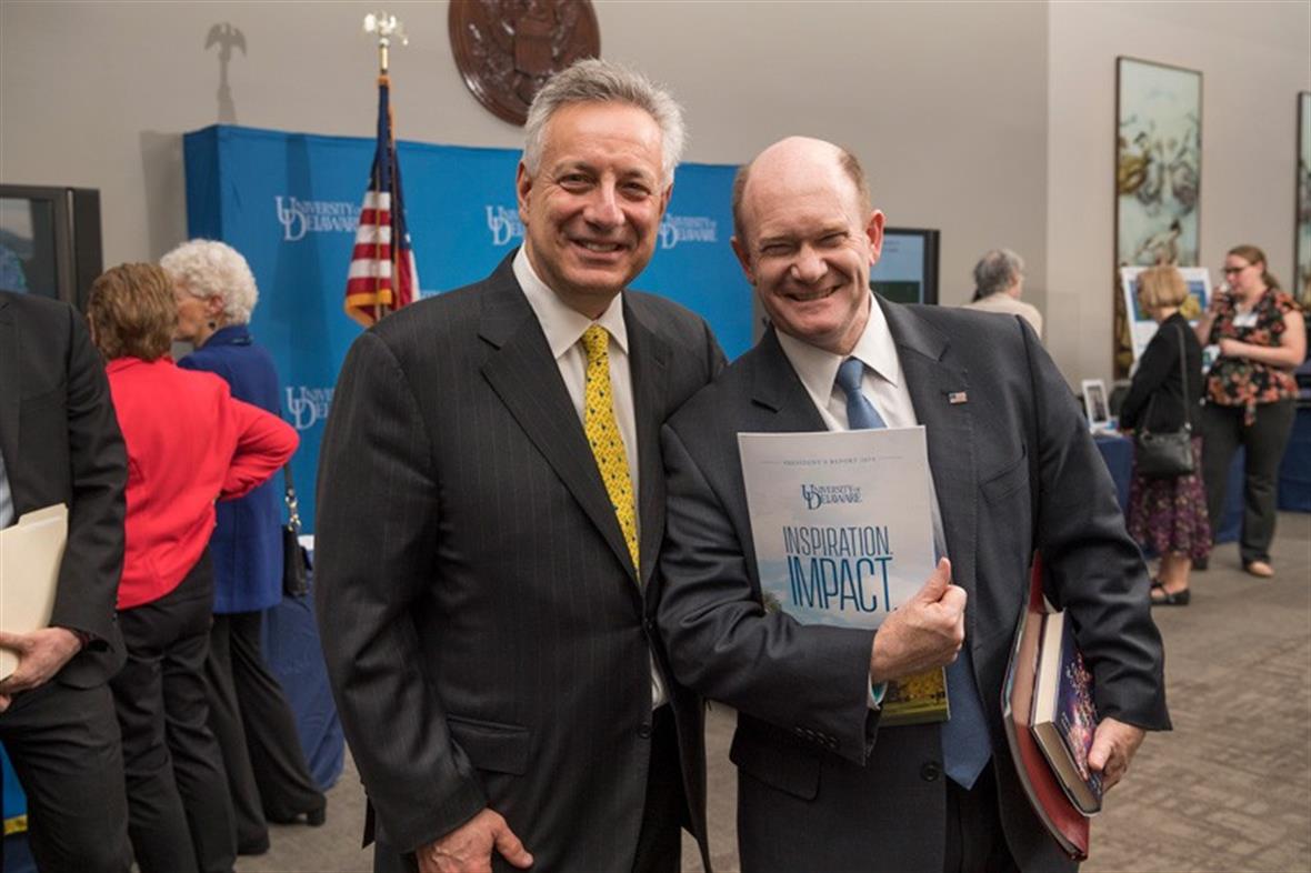 U.S. Sen. Chris Coons (right) has a degree in chemistry and is a powerful advocate for University of Delaware research. Here he shows off his new copy of UD President Dennis Assanis annual report.