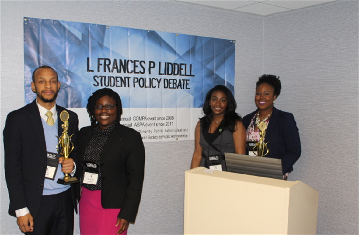 Four students post with their award after finning the L. Frances P. Liddell Student Policy Debate.