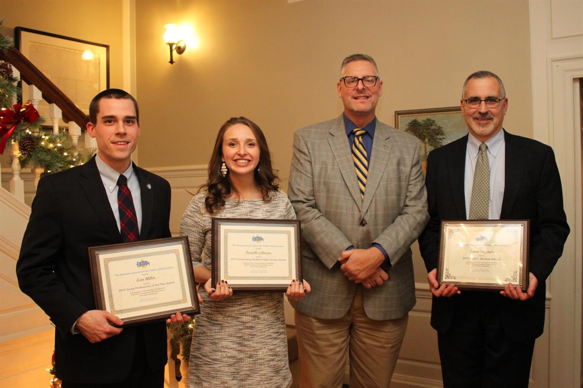 Evan Miller, Danielle Littmann, DAPA President Gene Dvornick, and Bert Scolietti pose for a photo with their award plaques at the foot of the stairs at Buena Vista Conference Center.
