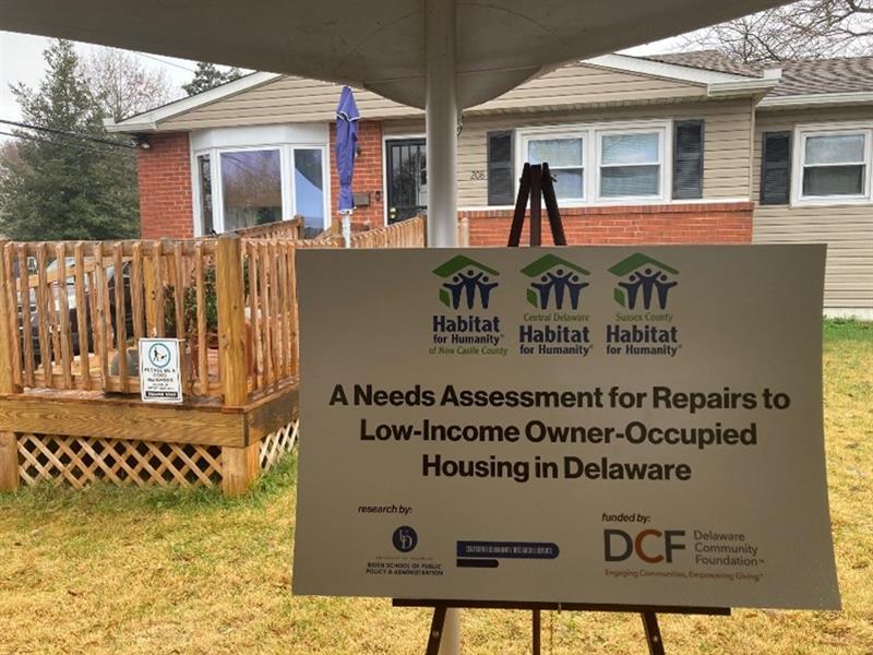 Sign in front of house reading A Needs Assessment for Repairs to Low-Income Owner-Occupied Housing in Delaware