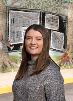 Portrait of Jillian Cullen standing outside in front of a painted mural.