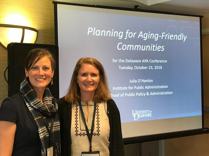 Julia O'Hanlon and Nicole Minni pose in front of their PowerPoint presentation focused on aging in place at the Regional Conference of the American Planning Association.