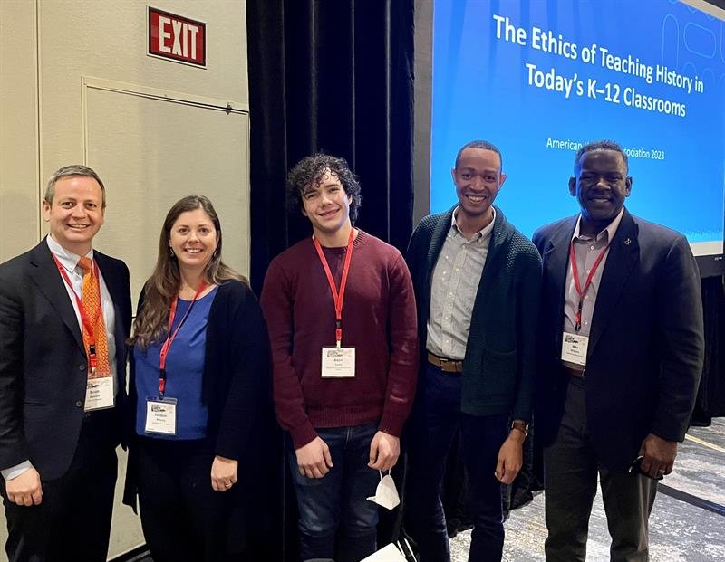 Panelists pose in front of presentation screen that reads "The Ethics of Teaching History in Today's K-12 Classrooms," for photo at national conference 
