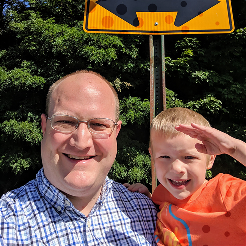 Troy and Owen Mix standing in front of a street sign.