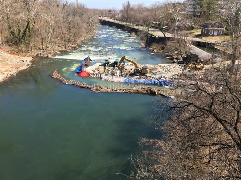 Crews in the middle of the Brandywine River work to remove a 115-year-old dam that was built to allow Wilmington water pipes to cross the river. (Photo credit: Mark Eichmann/WHYY