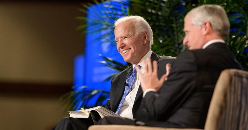 Joe Biden and Jon Meacham speaking on stage together.