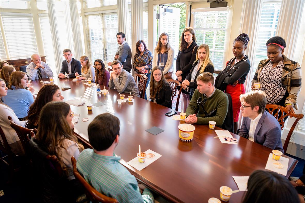 Students gathered around a table with Joe Biden.