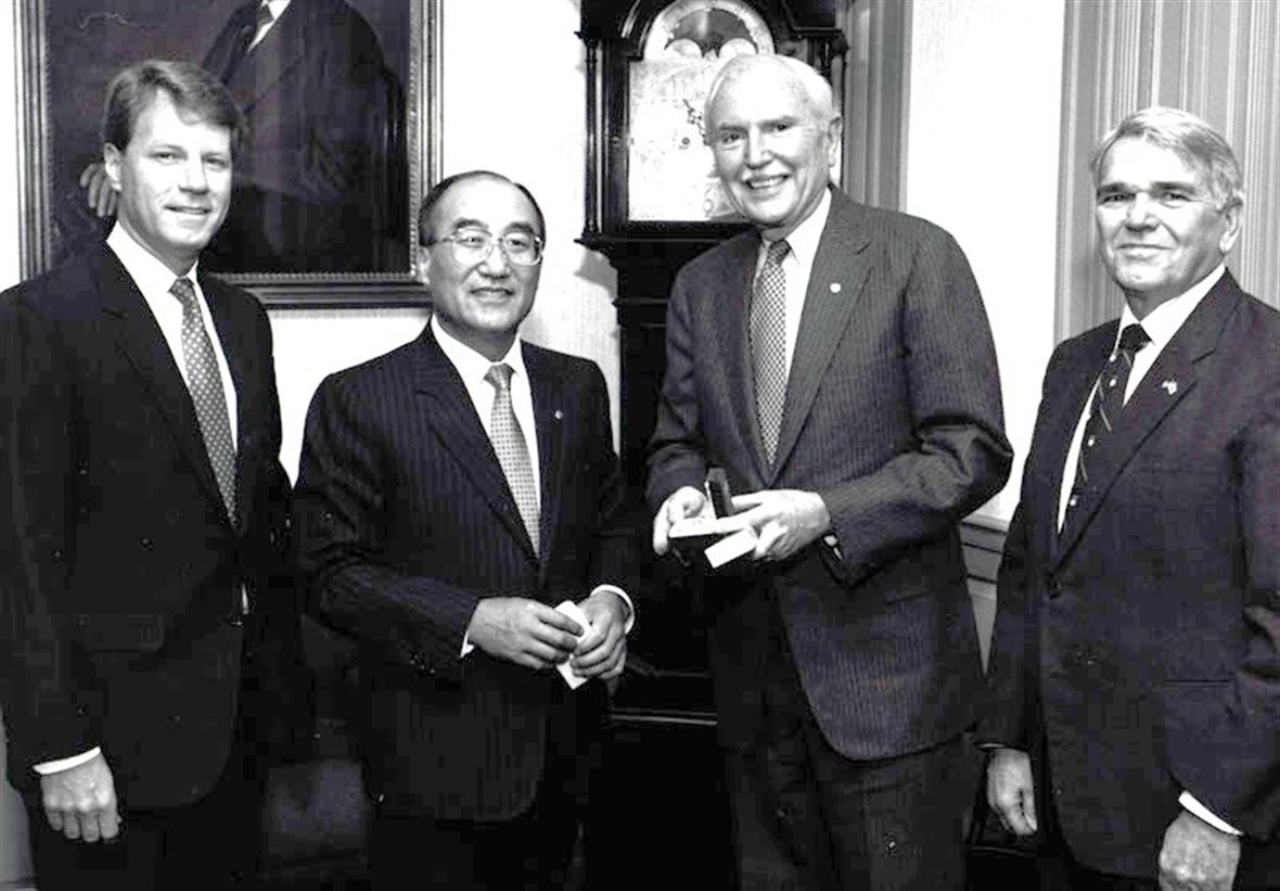 Four men pose together.